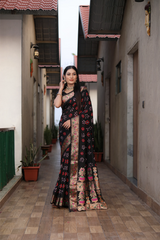 Woman wearing a pink saree with a colorful border outdoors.