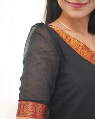 Black saree with orange and red border worn by a person