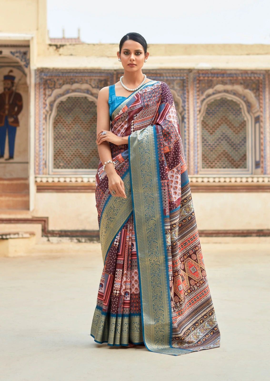 Woman wearing a traditional saree in an ornate indoor setting