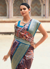 Woman wearing a traditional saree with a patterned design in an outdoor setting