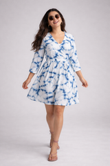 Woman wearing a blue and white tie-dye dress on a gray background