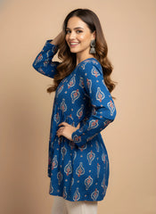 Woman wearing a blue patterned dress against a beige background