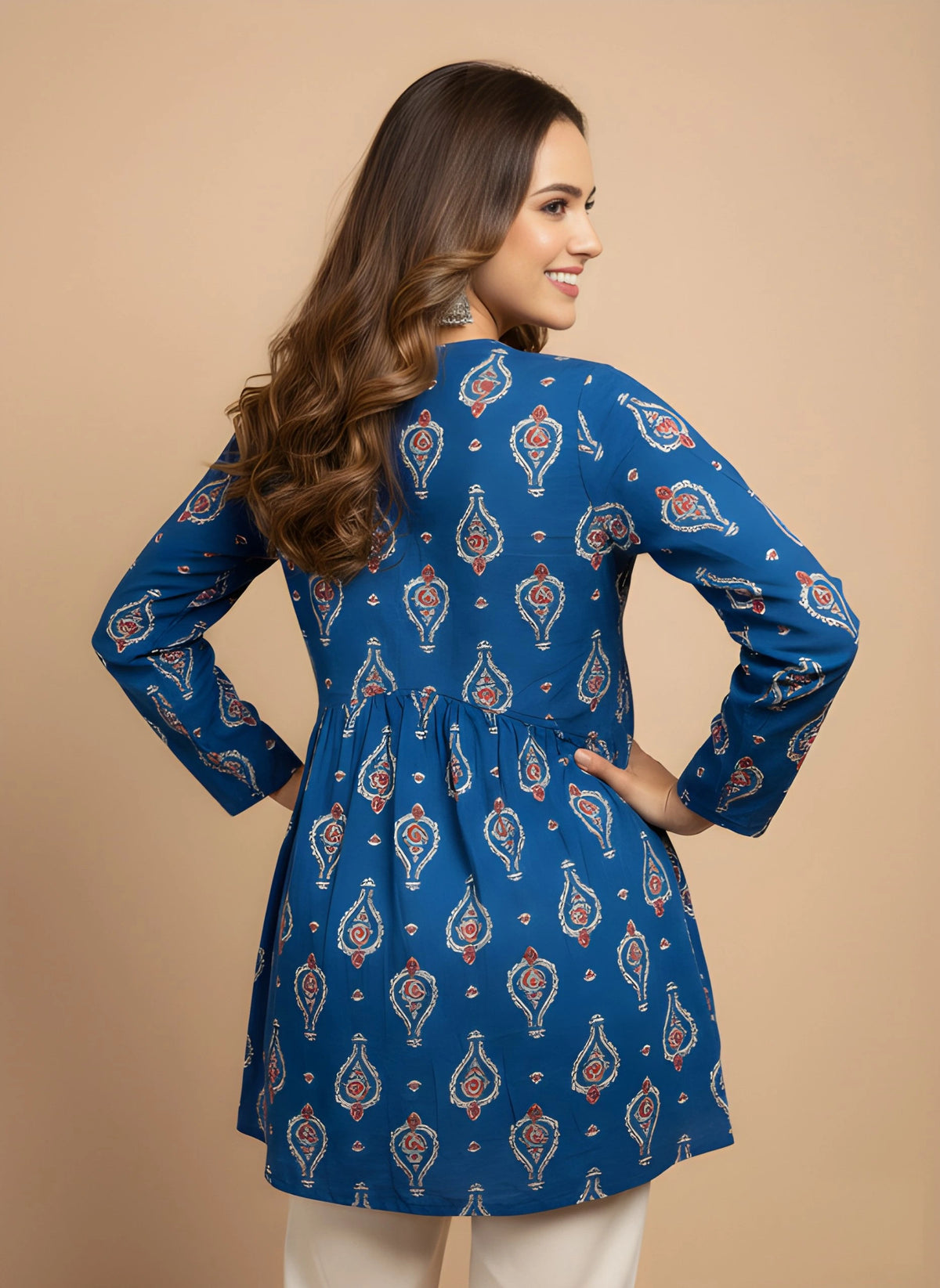 Woman wearing a blue patterned dress against a beige background