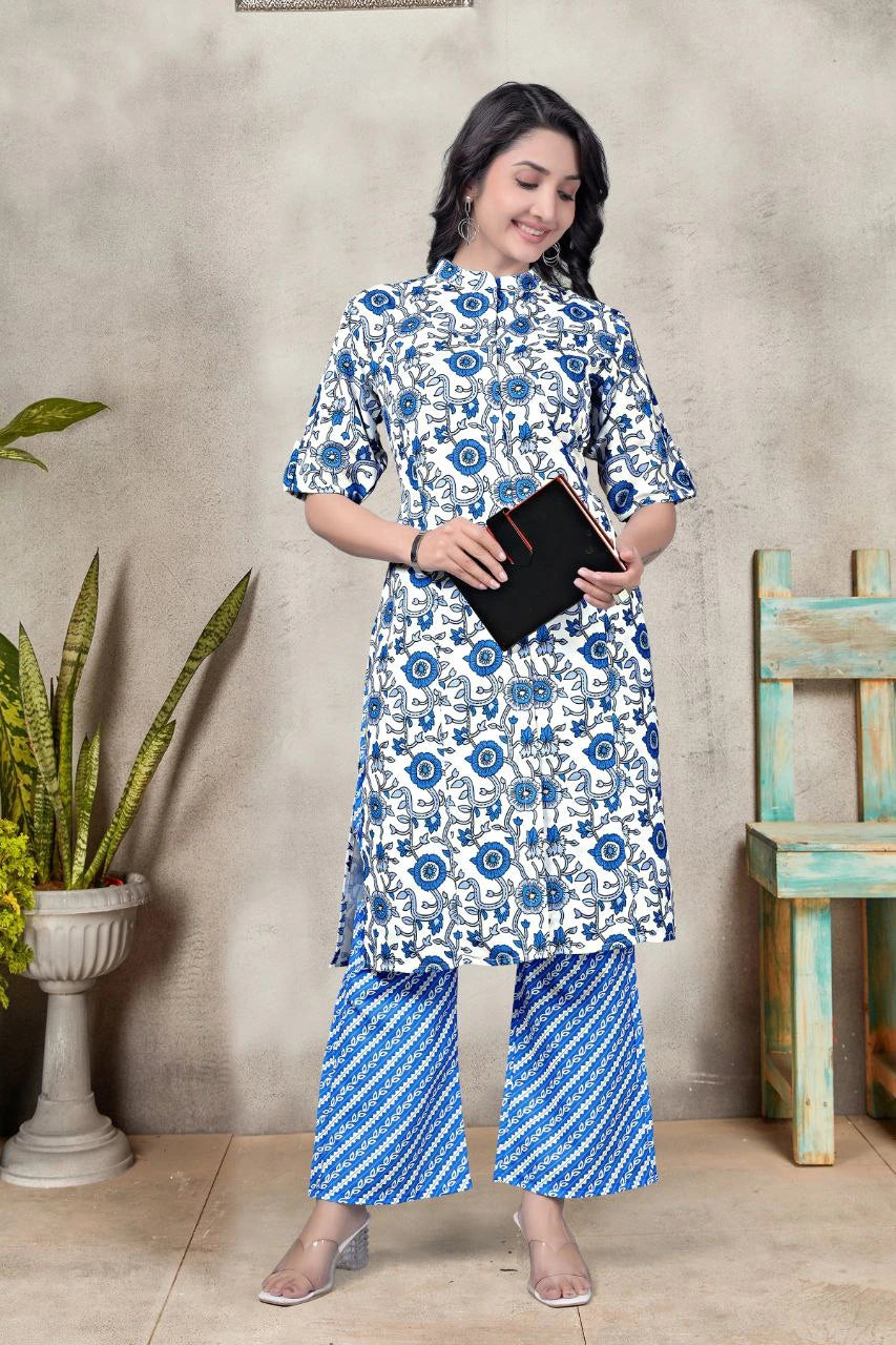 Woman wearing a blue and white floral outfit standing against a textured wall.
