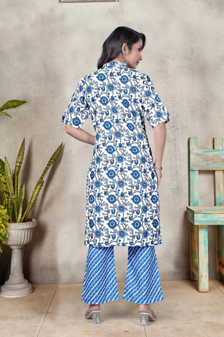 Woman wearing a blue and white floral kurta with matching pants against a beige wall.
