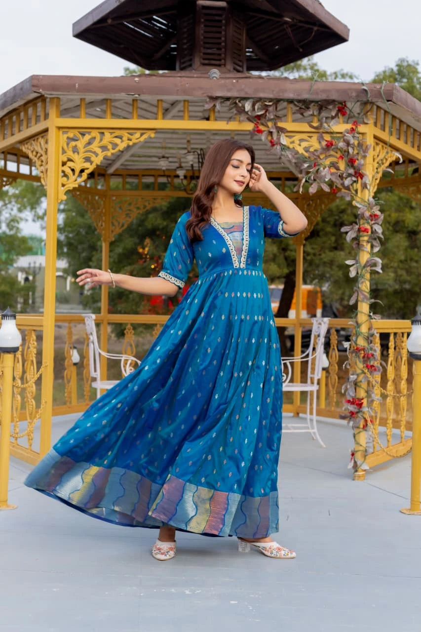 Woman in a blue dress standing in front of a decorative gazebo.