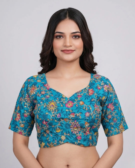 Woman wearing a blue floral blouse against a plain background