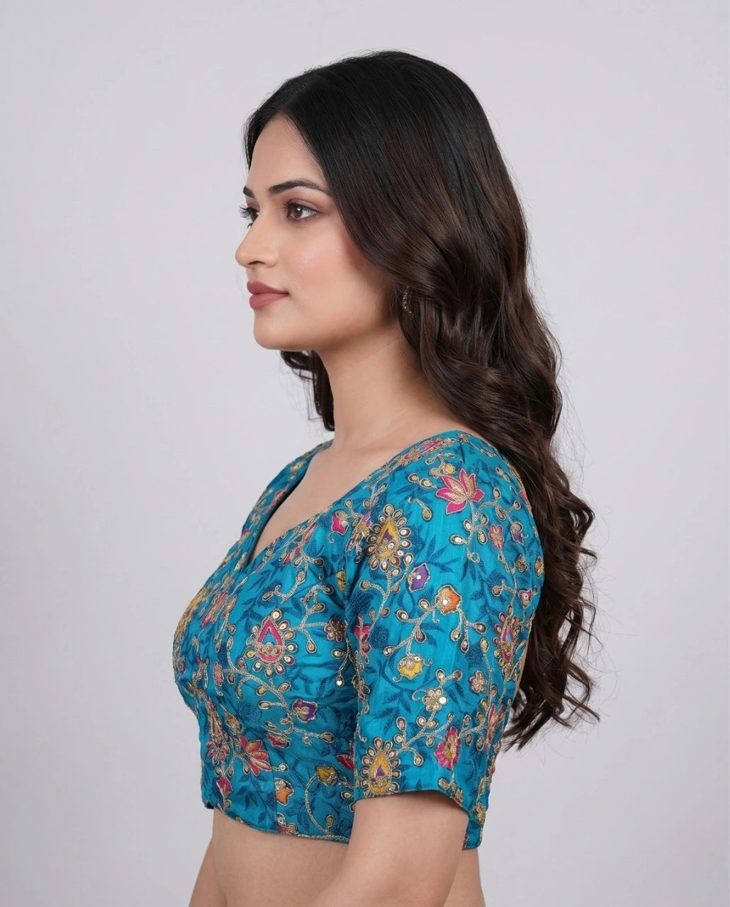 Woman wearing a blue floral blouse against a white background