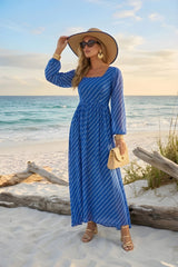 Woman in a blue striped dress and sun hat on a beach