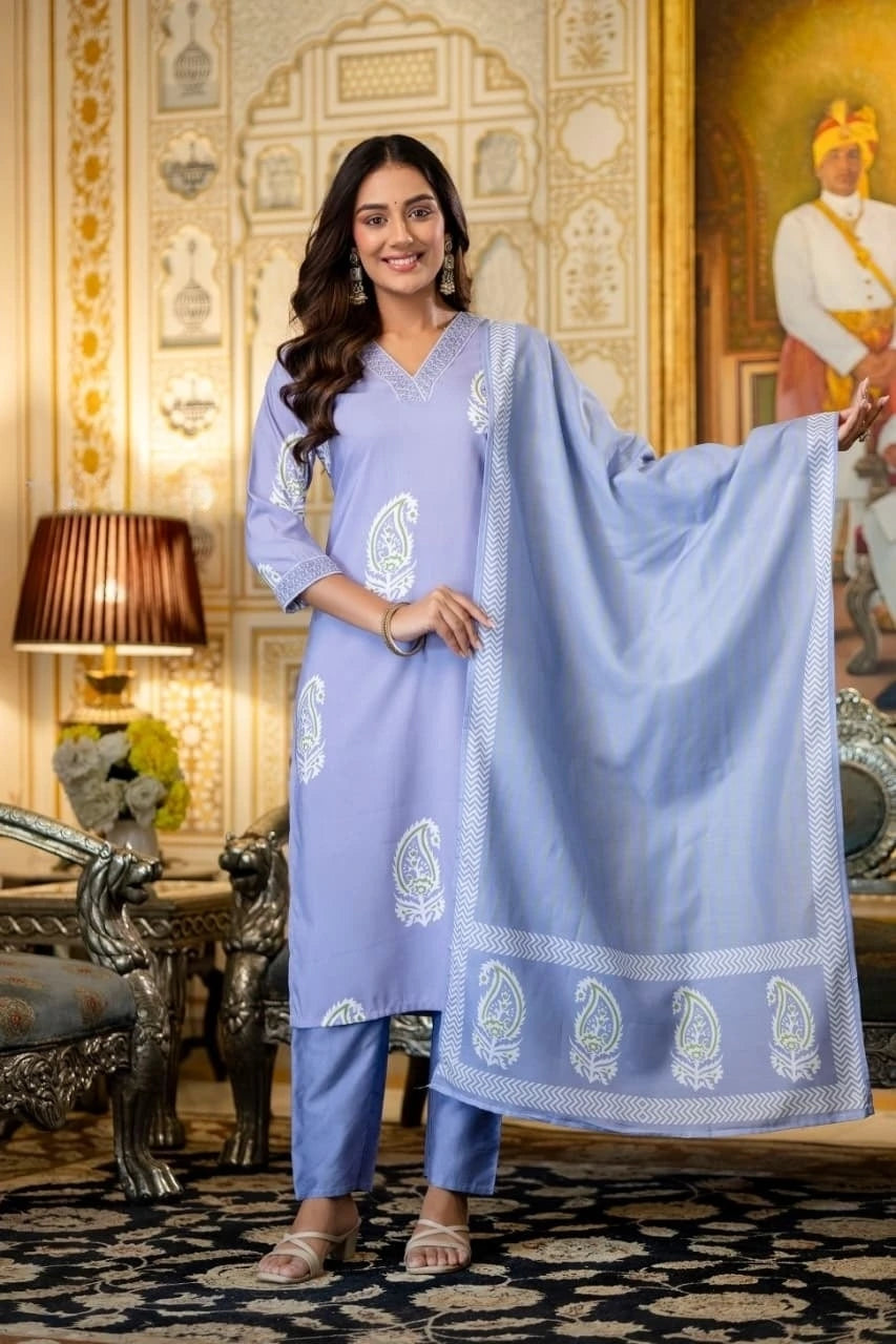 Woman in a light blue traditional outfit with a matching dupatta in an ornate room.