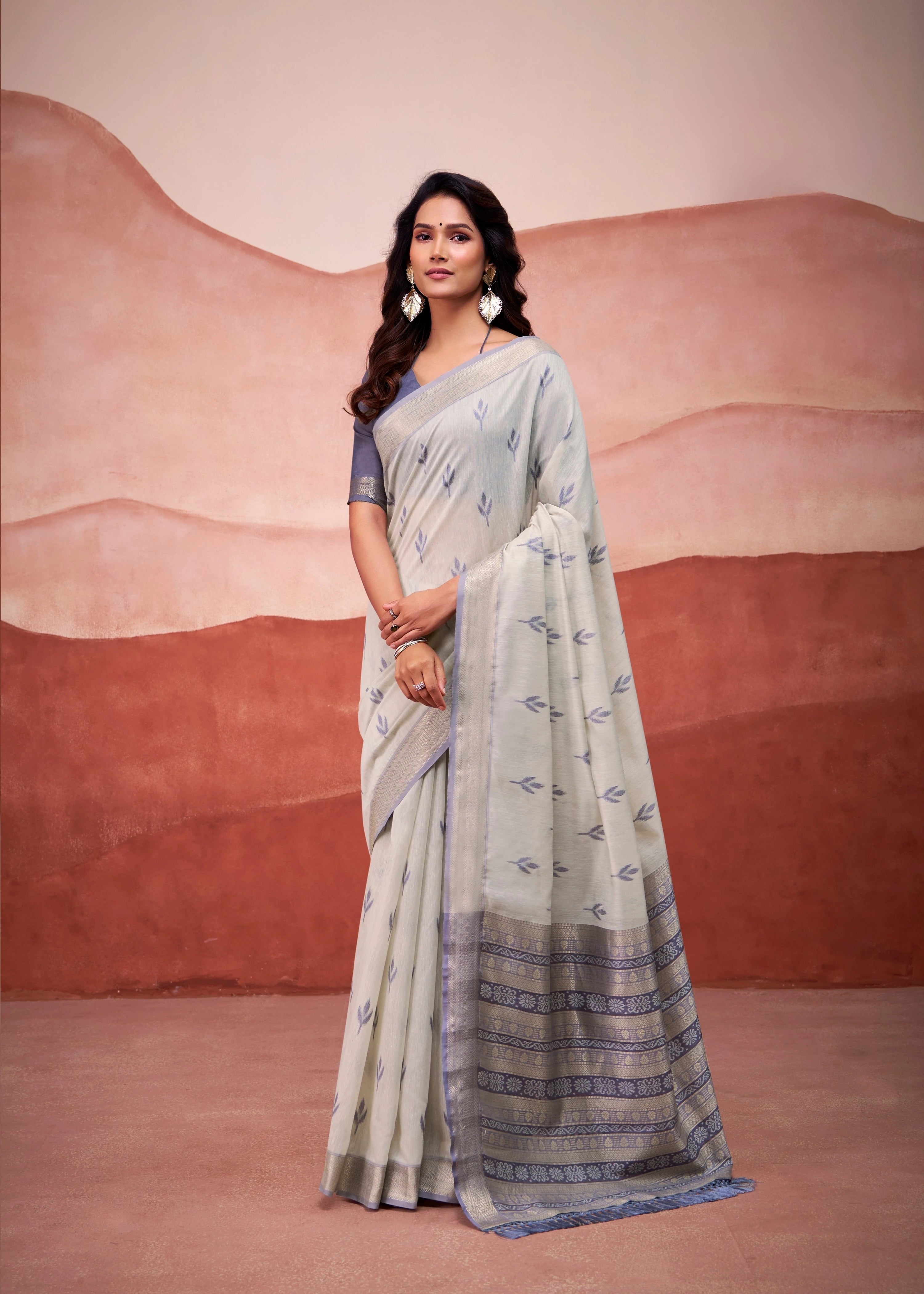 Woman in a light blue saree with a desert landscape background