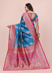Woman wearing a pink and blue saree with intricate patterns on a beige background