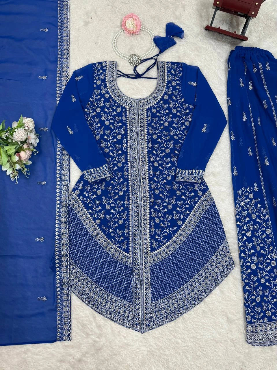 Blue embroidered traditional outfit with matching dupatta on a light gray background