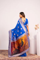 Woman wearing a blue saree with a peacock design on a white background