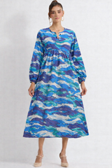 Woman wearing a blue and green patterned dress on a white background