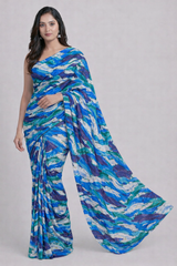 Woman wearing a blue and green patterned saree on a gray background