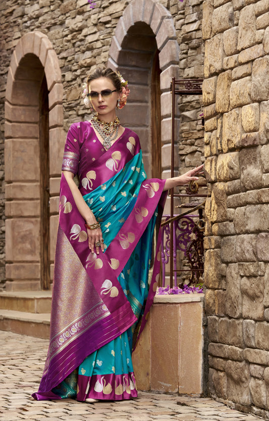 Woman in a traditional saree standing in front of stone arches.