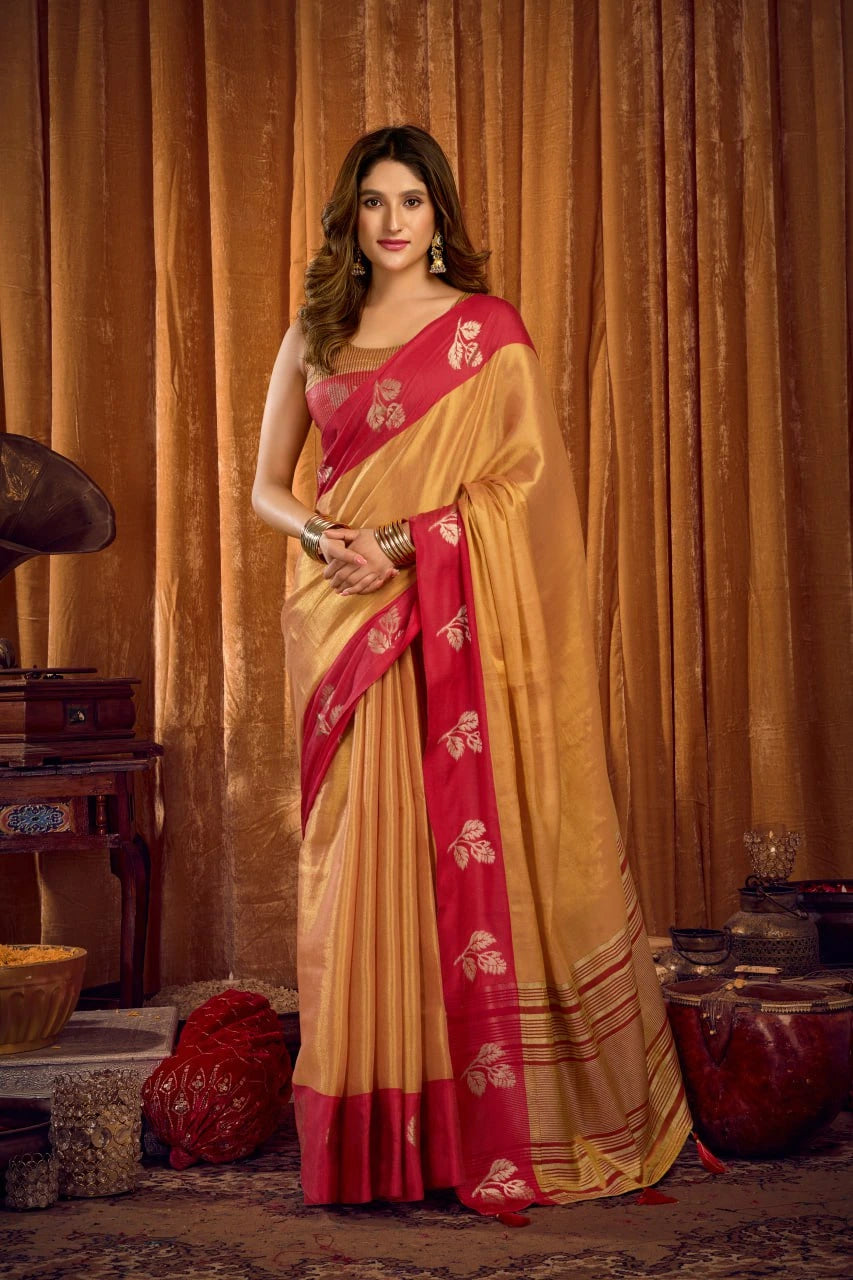 Woman wearing a traditional yellow and red saree in a decorated room.