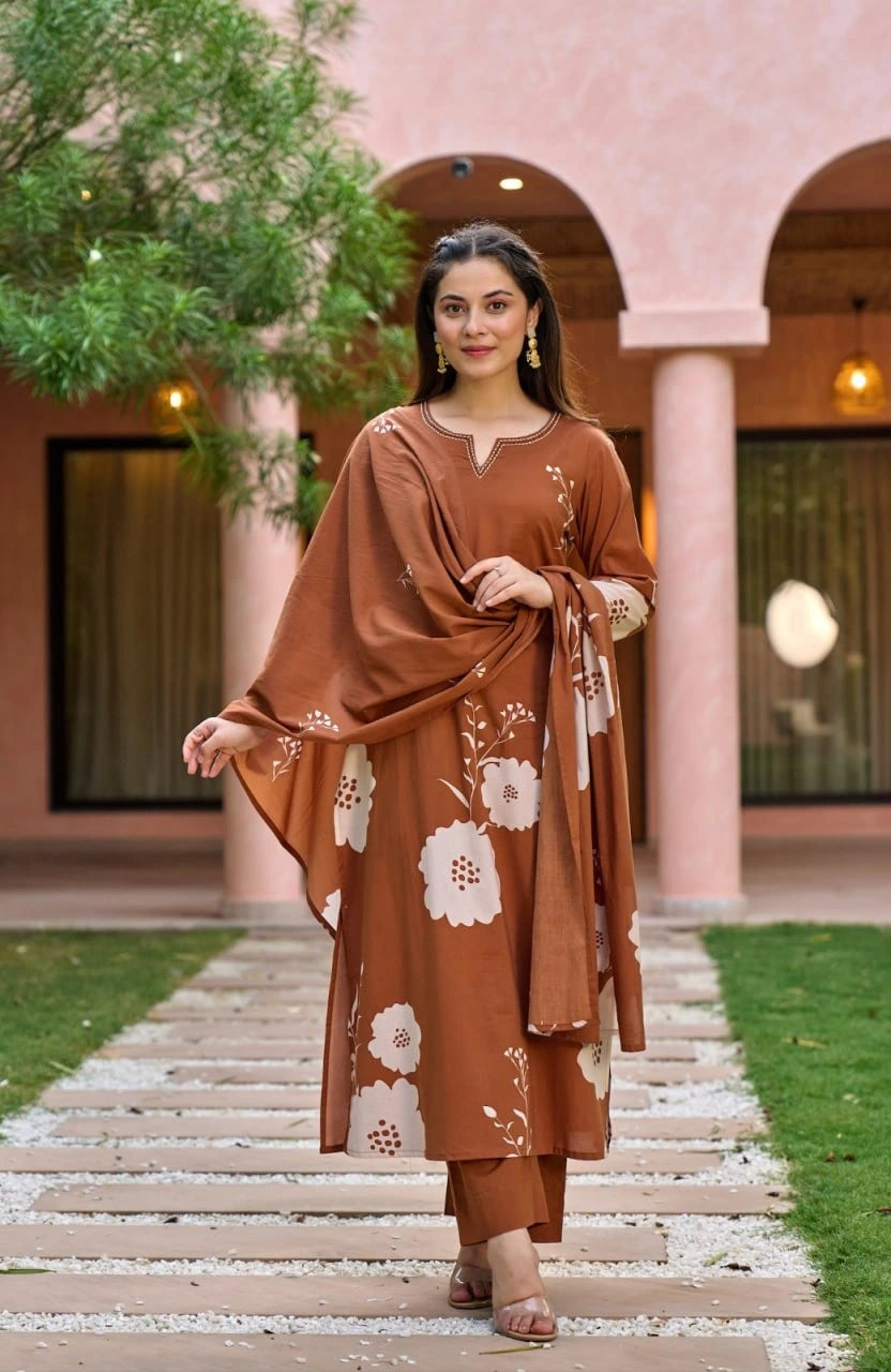 The woman poses in the same terracotta kurta set, now with a matching dupatta draped gracefully over one shoulder. The courtyard's pink-toned architecture and arched entryways provide a warm, scenic background