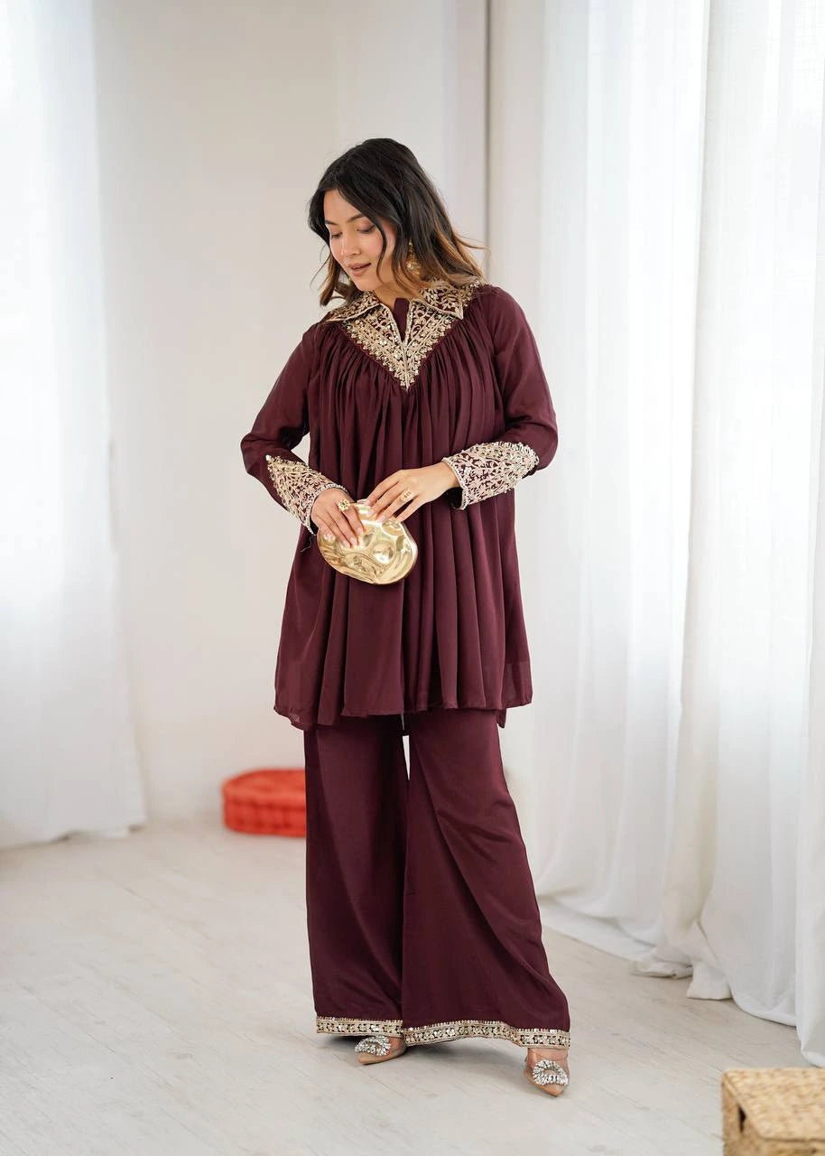 Woman wearing a burgundy outfit with lace details in a white room.