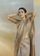 Woman wearing a beige saree with a blurred background