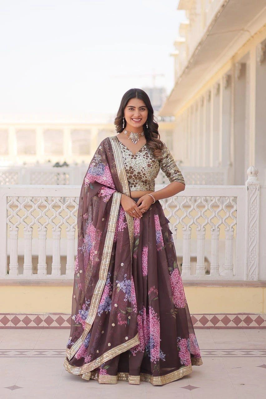 Woman in a traditional outfit with floral patterns standing in a decorative interior setting.