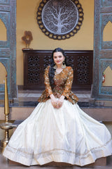 Woman in traditional outfit sitting in a decorative interior setting