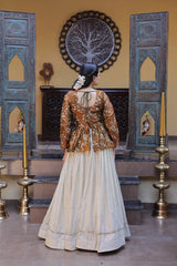 Woman in a traditional outfit standing in a decorated room with ornate doors and wall art.