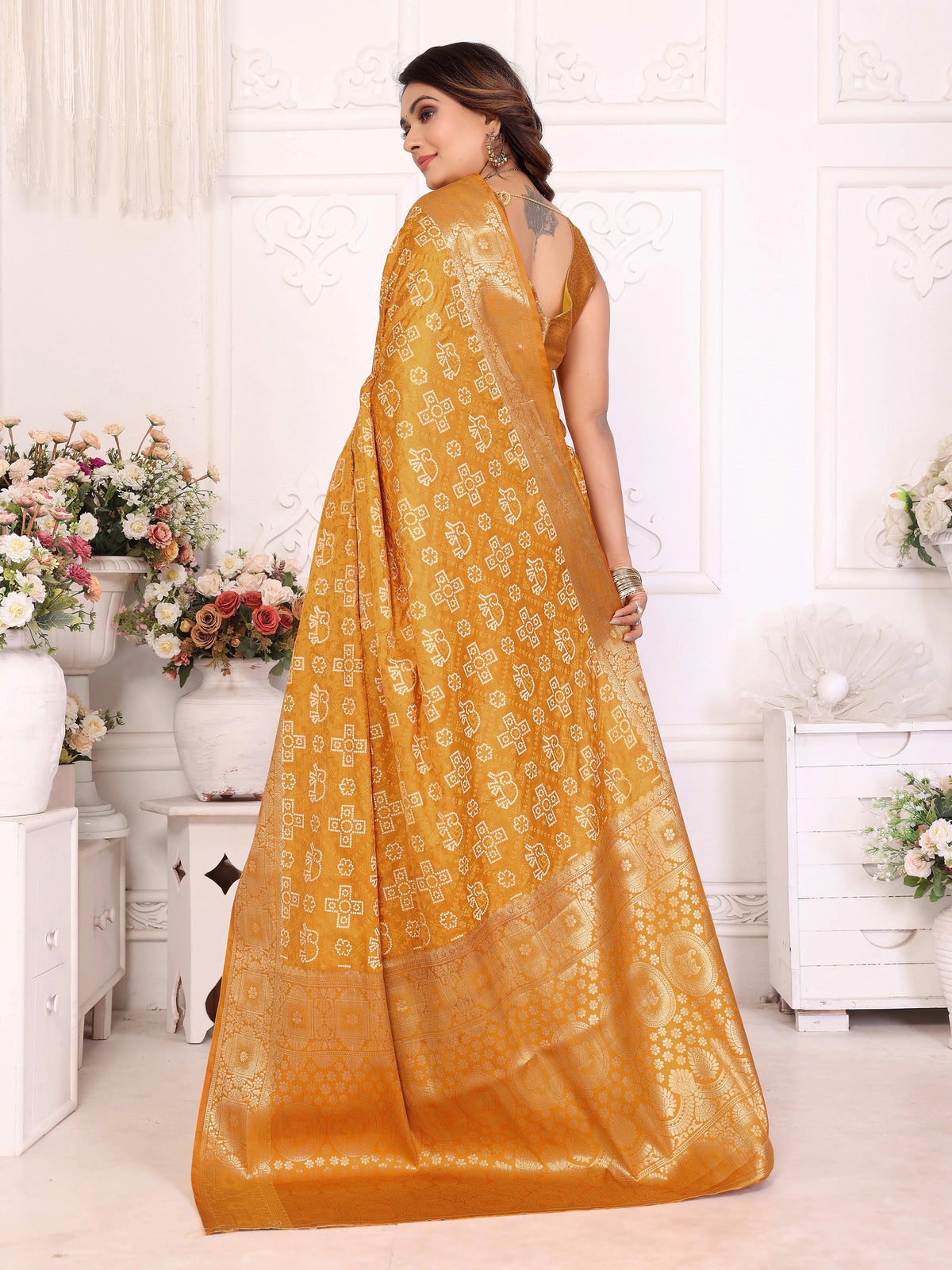 Woman wearing a mustard yellow saree with a white background