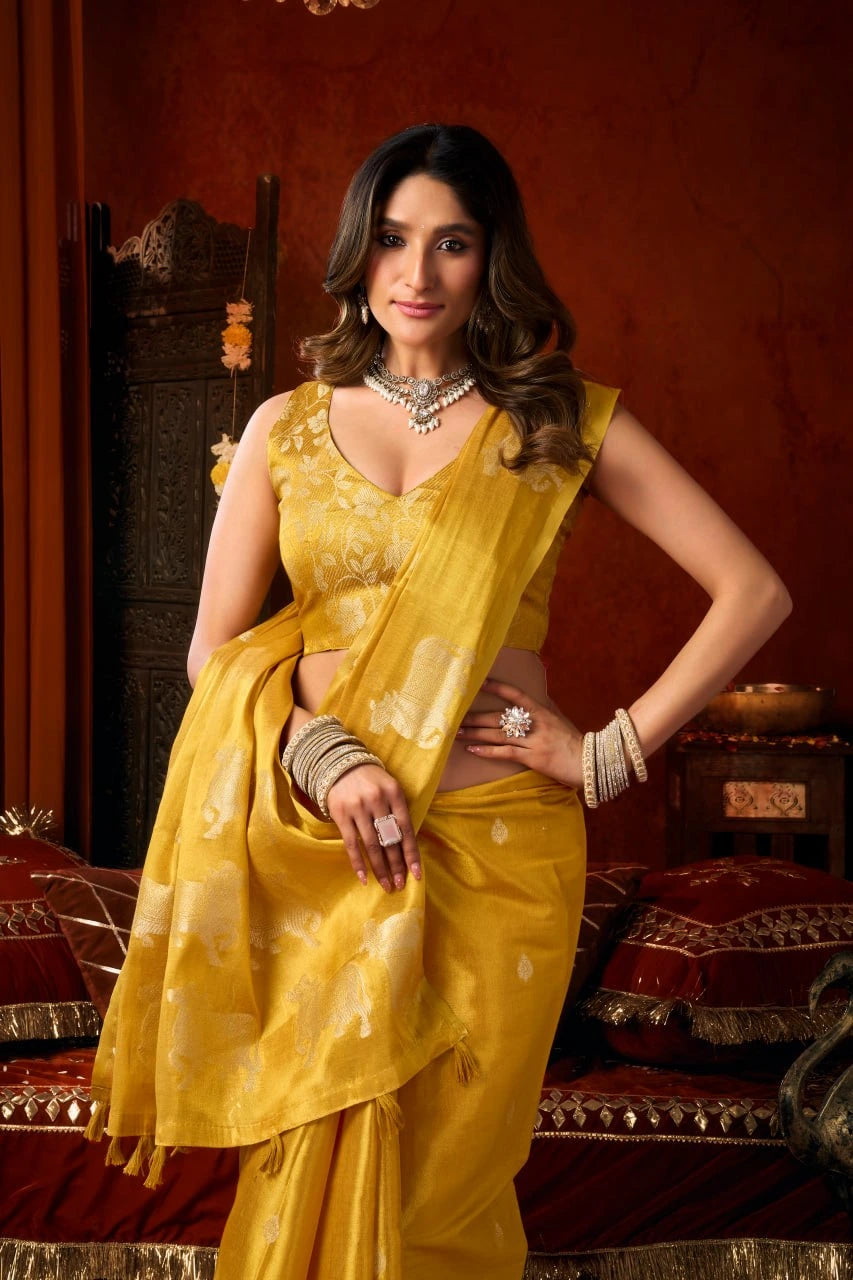 Woman in a yellow saree posing in an ornate room.