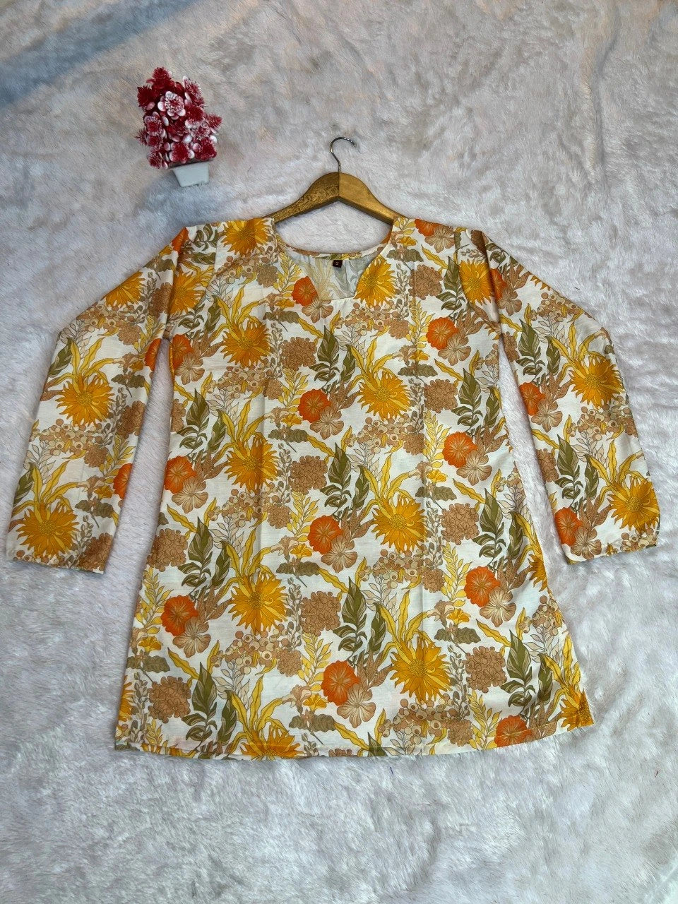 Floral patterned dress on a hanger against a textured gray background