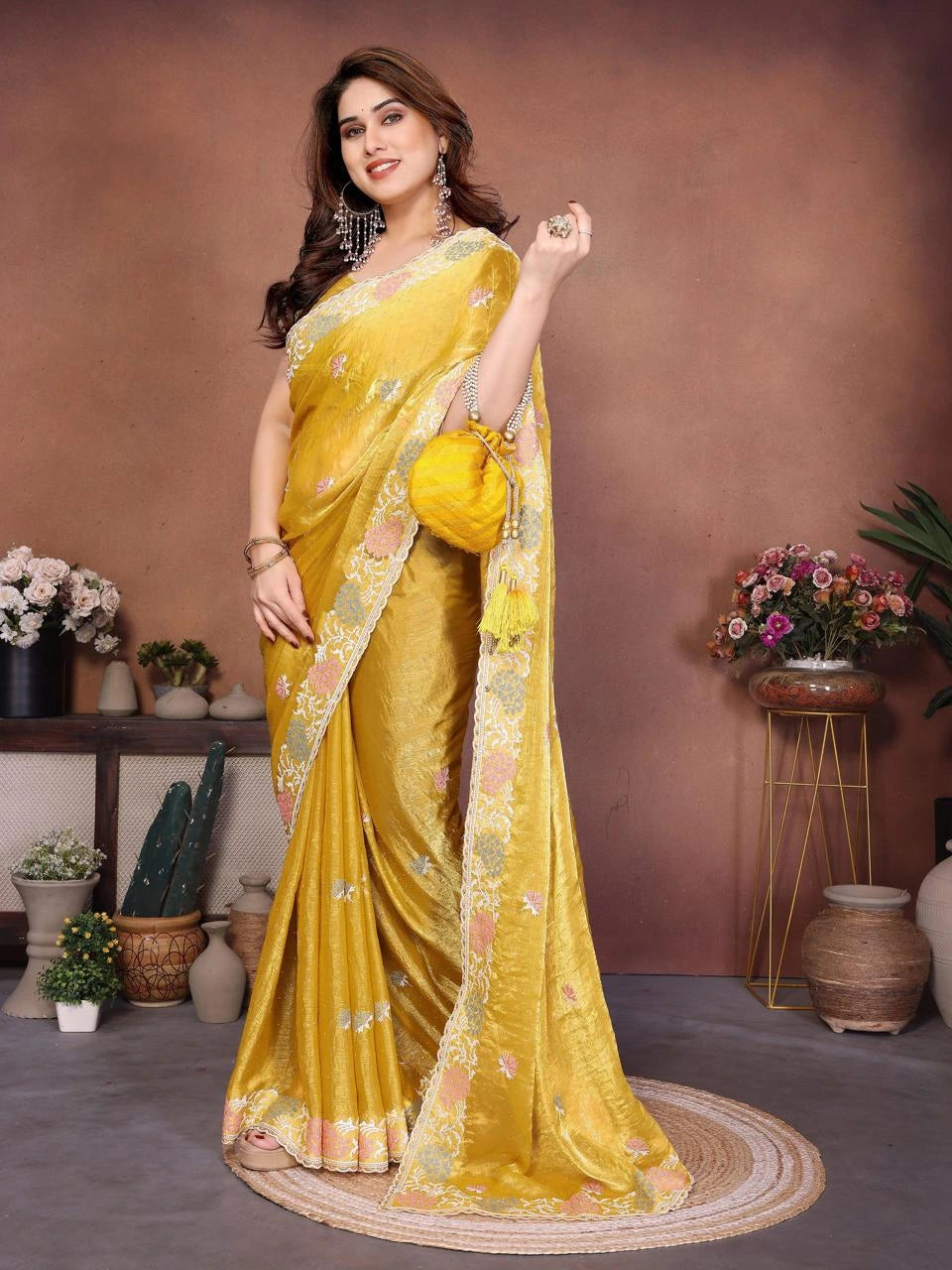 Woman in a yellow saree with floral decorations in an indoor setting