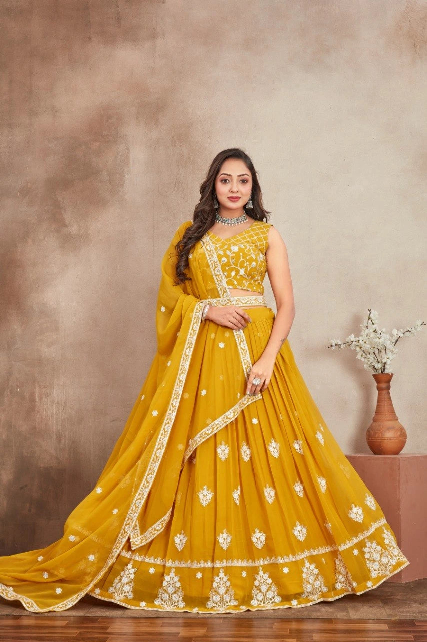 Woman in a yellow embroidered traditional outfit standing against a brown background
