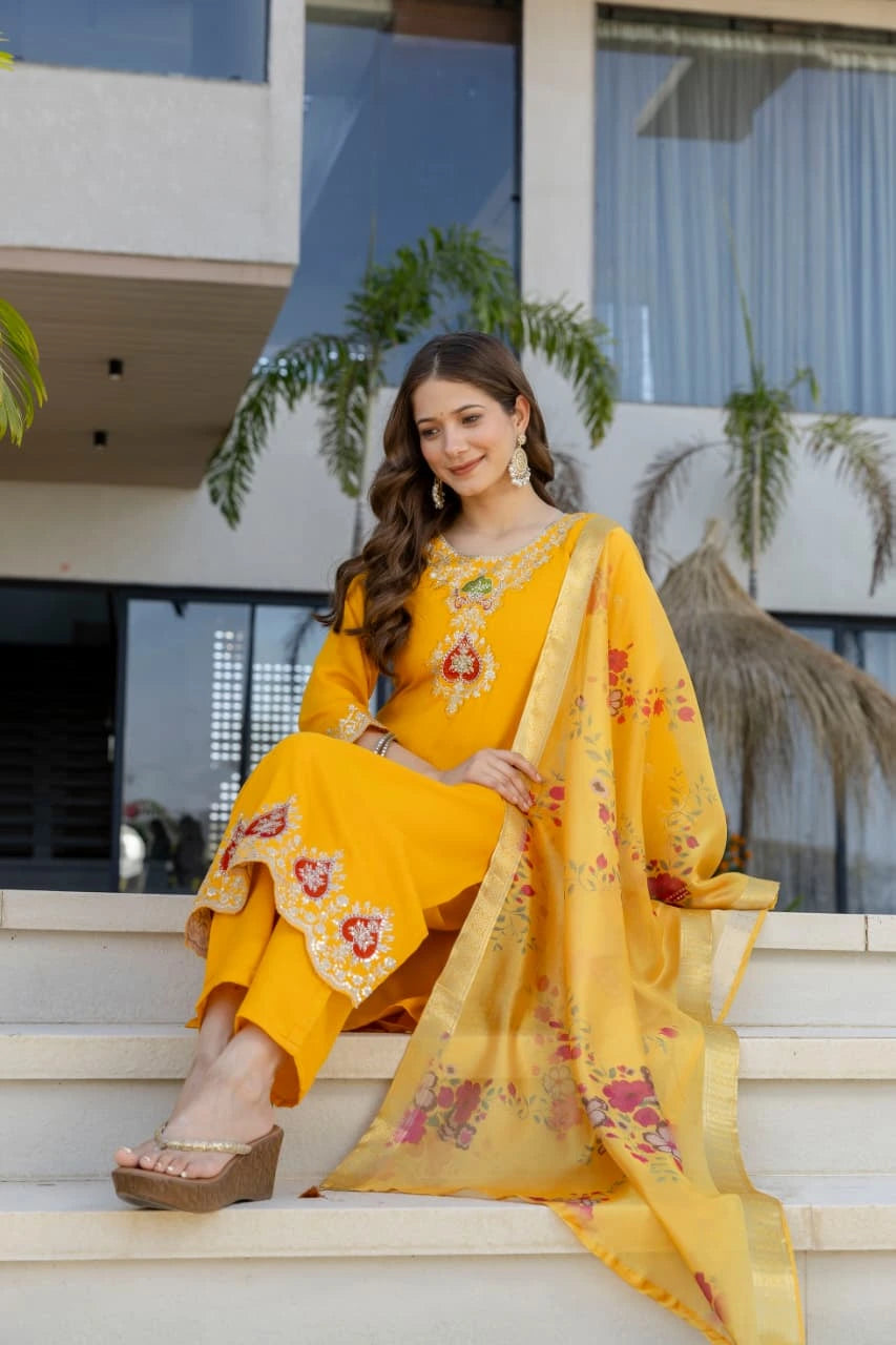 Woman in a yellow traditional outfit sitting on steps outdoors.