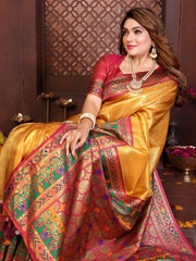 Woman in a traditional saree with intricate patterns and jewelry, sitting indoors.