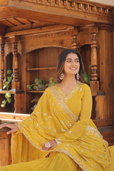 Woman in a yellow traditional outfit sitting in a wooden interior setting