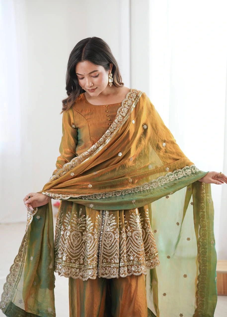 Woman wearing a mustard yellow and green traditional outfit with intricate patterns.
