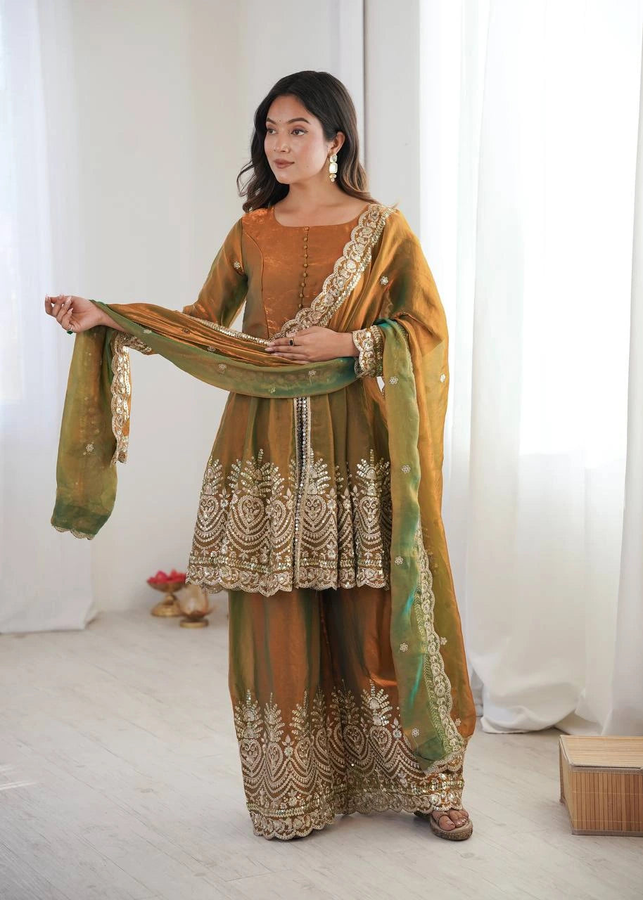 Woman wearing a traditional outfit with intricate patterns in a bright room.