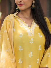 Woman wearing a yellow traditional outfit with white floral patterns