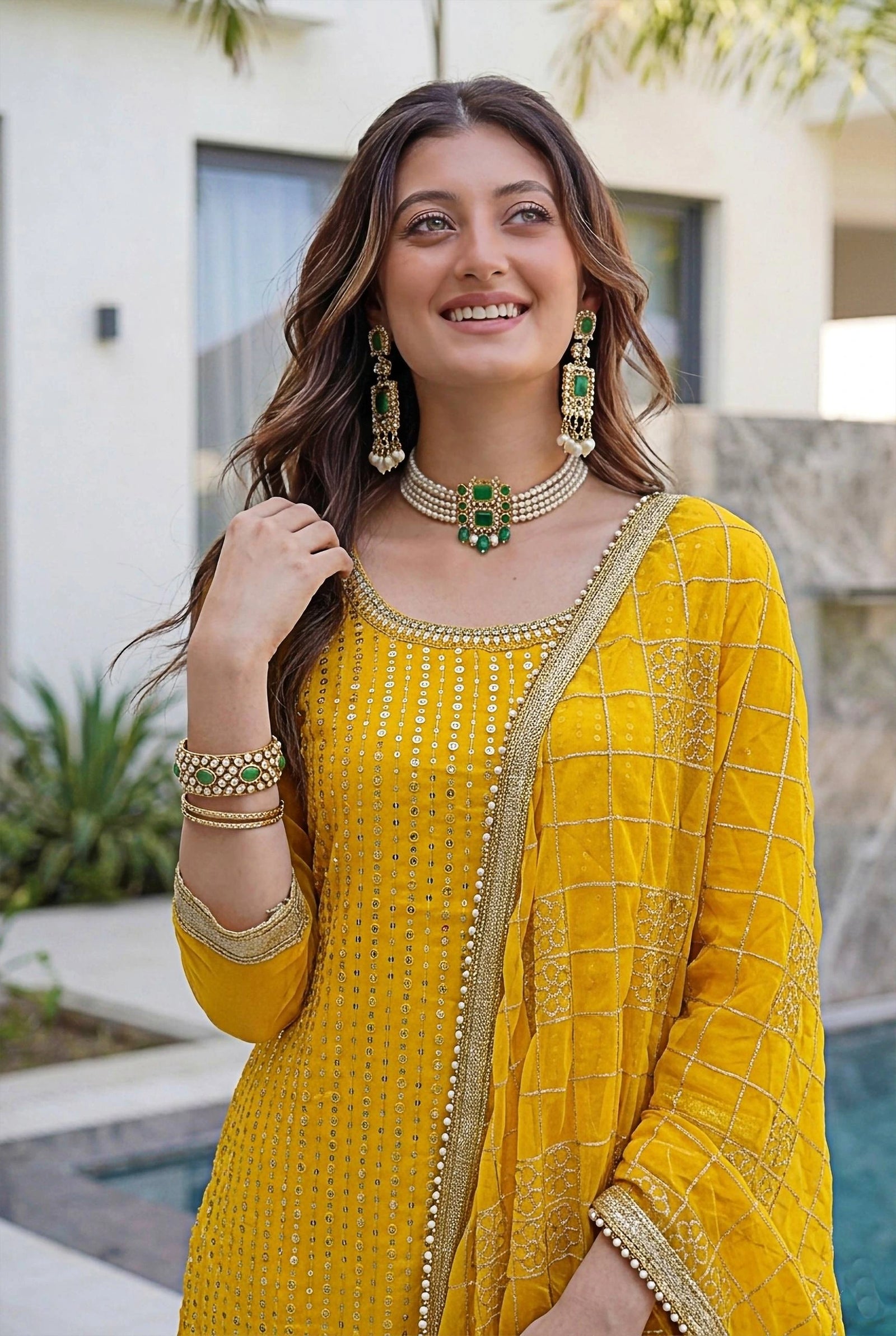 Woman in a yellow traditional outfit with jewelry outdoors