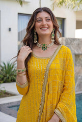 Woman in a yellow traditional outfit with jewelry outdoors