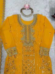 Yellow embroidered dress with intricate patterns on a light gray background