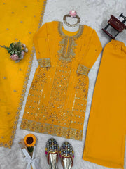 Yellow embroidered traditional outfit with accessories on a light gray background