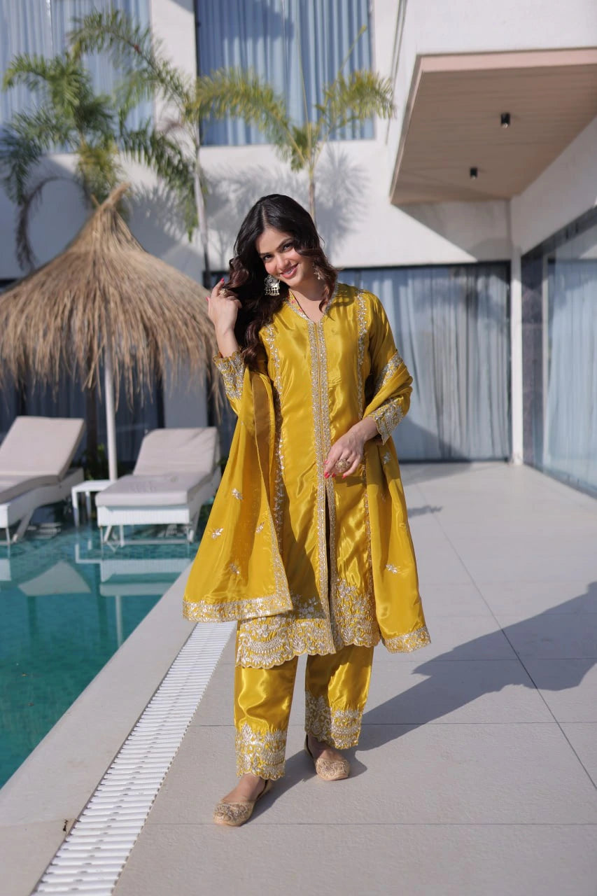 Woman in a yellow traditional outfit standing by a poolside.