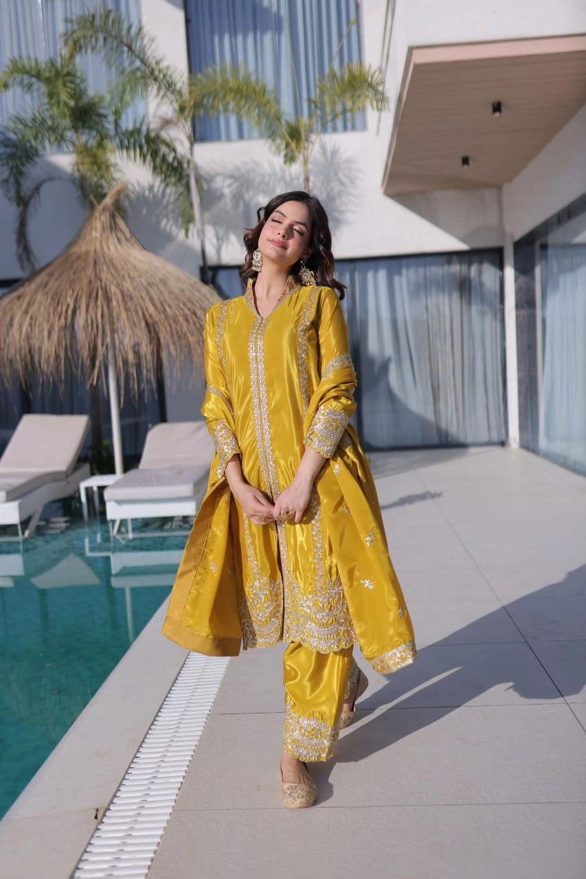 Woman in a yellow traditional outfit standing by a poolside.