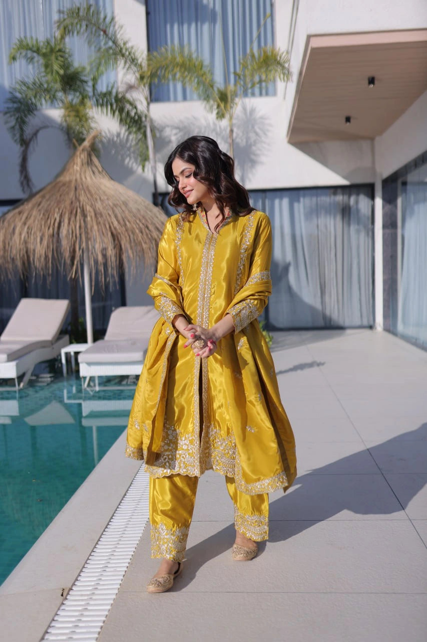 Woman in a yellow traditional outfit standing by a poolside.