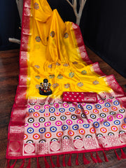 Yellow saree with red and multicolor patterned border on a wooden surface