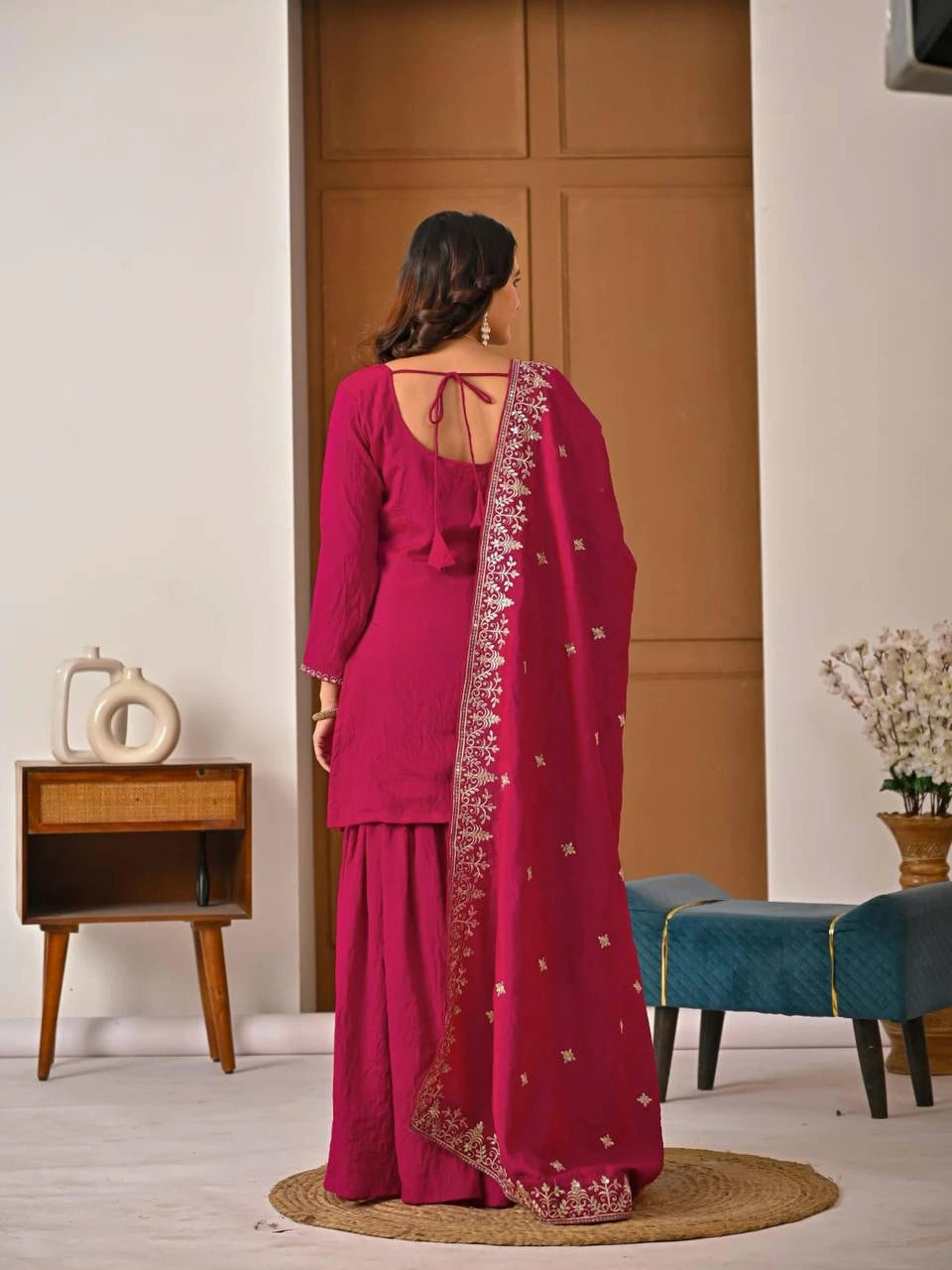 Traditional crimson red Vichitra suit with ornate embroidery patterns draped gracefully.