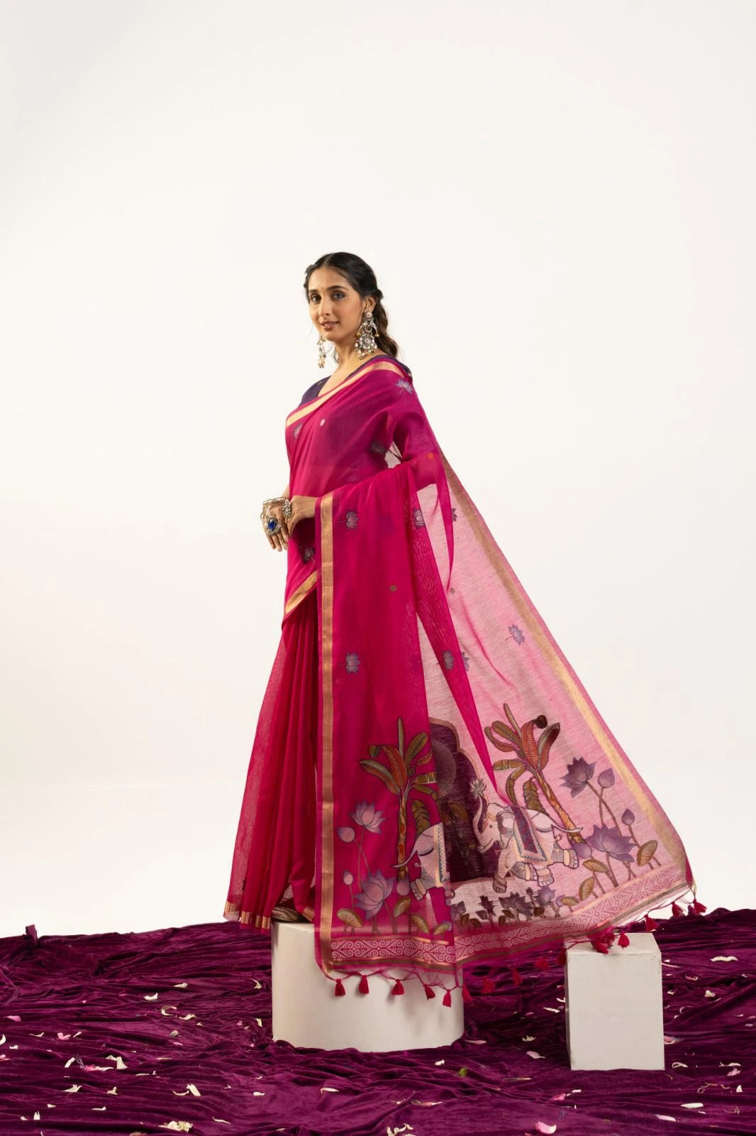 Woman wearing a pink saree with a white background