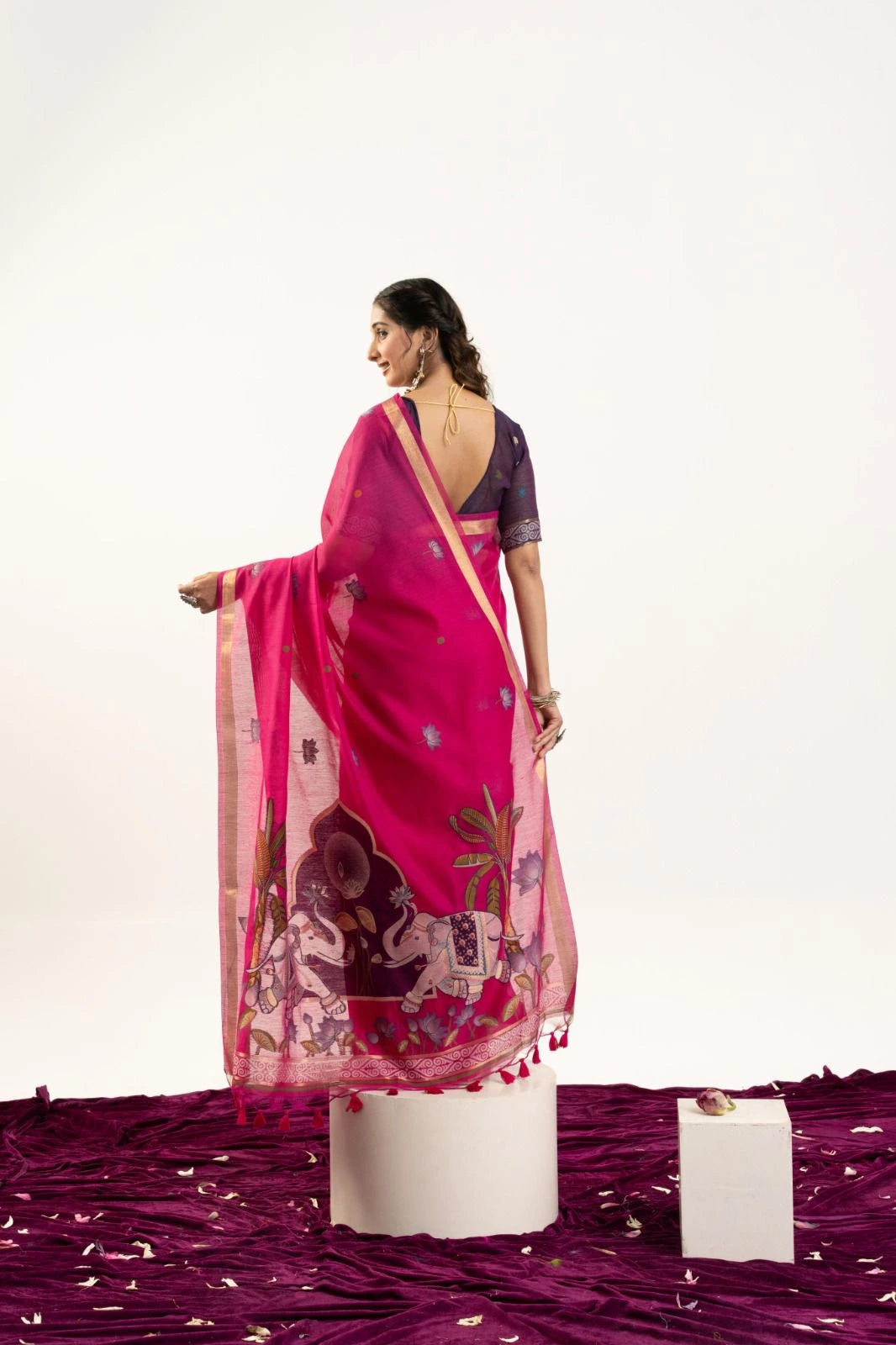 Woman wearing a pink saree with a white background